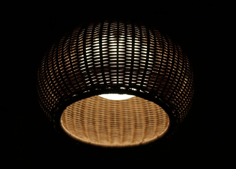 A beautifully illuminated handmade wicker lamp casting warm light in the dark.