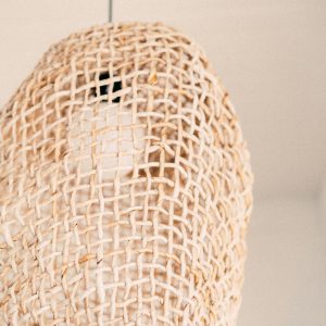 A close-up view of a handcrafted rattan lamp showcasing intricate weaving pattern.