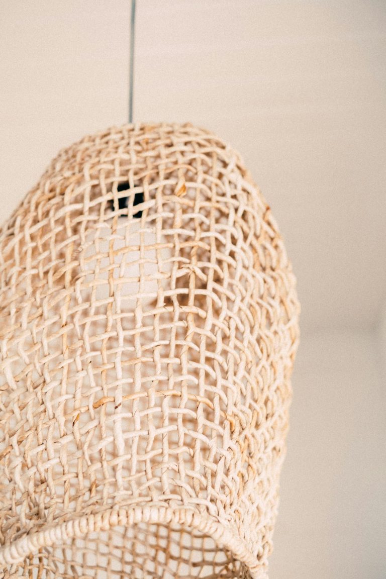 A close-up view of a handcrafted rattan lamp showcasing intricate weaving pattern.