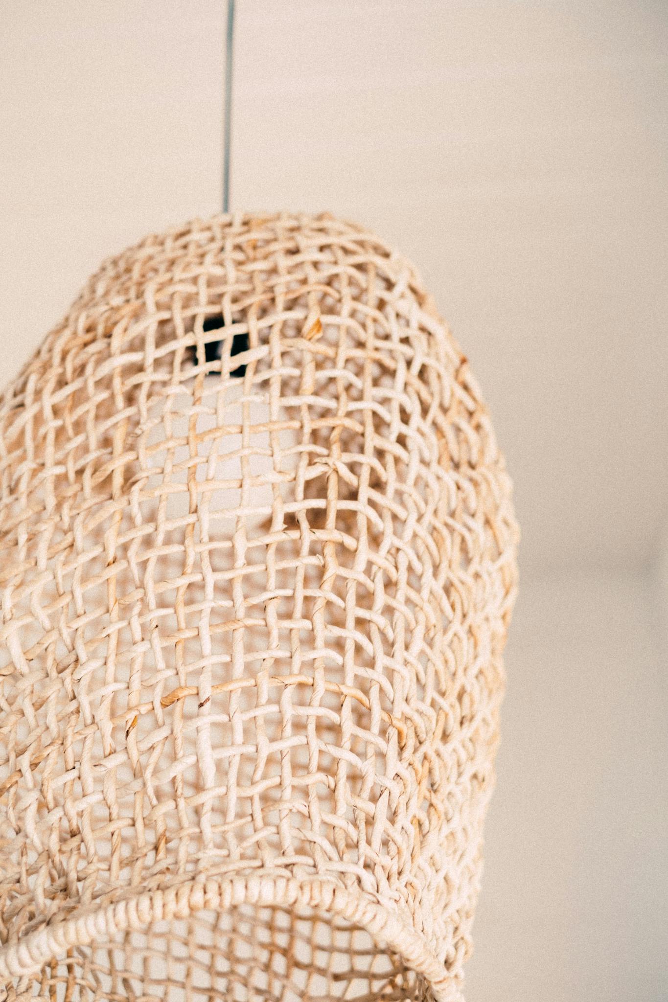 A close-up view of a handcrafted rattan lamp showcasing intricate weaving pattern.