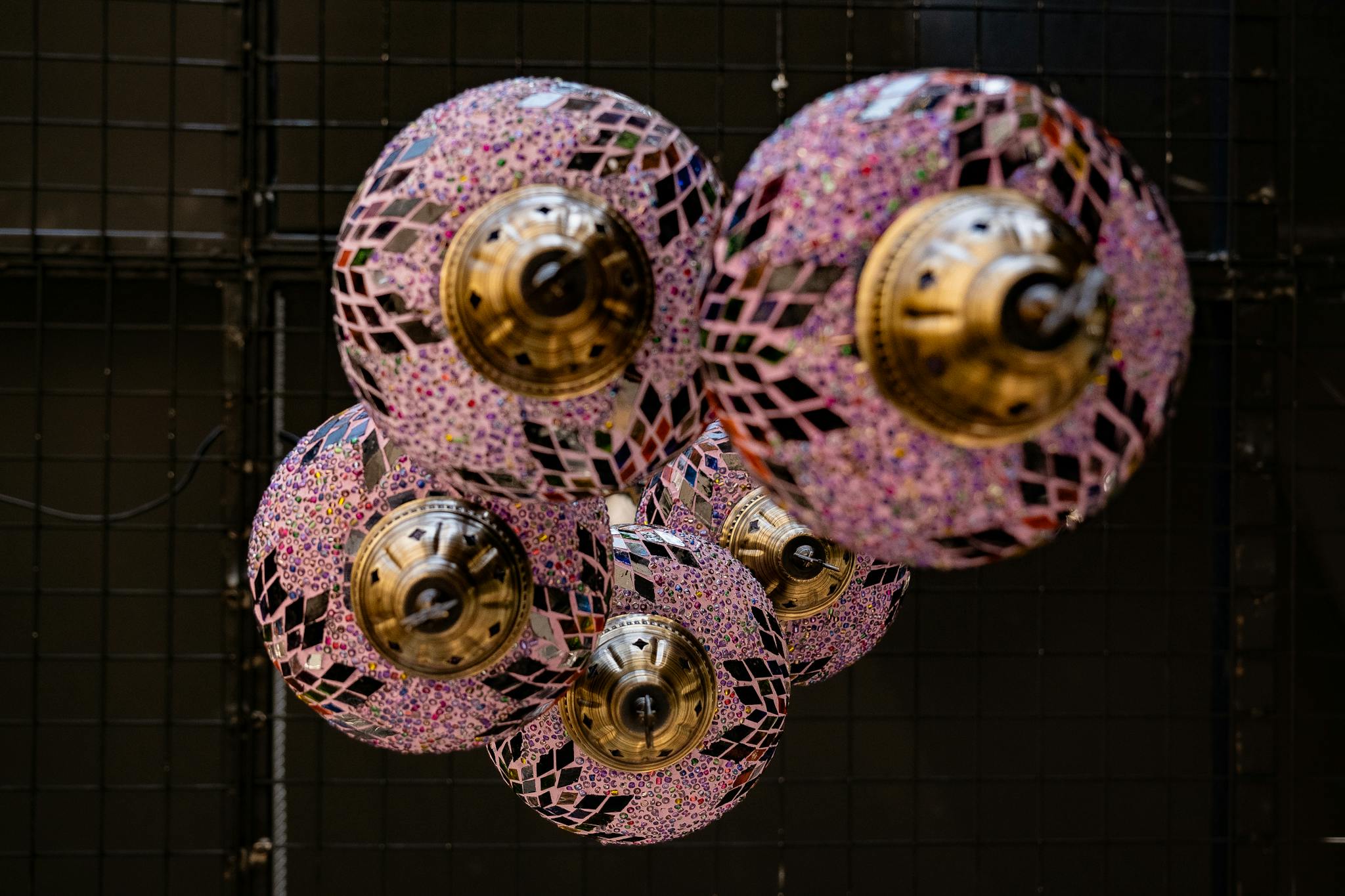 Vibrant mosaic lamps arranged in an ornamental pattern hanging indoors. Perfect for decor inspiration.