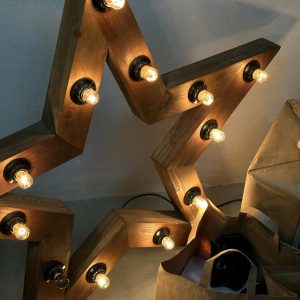 Warm wooden star lamp with glowing bulbs, perfect for home decor.
